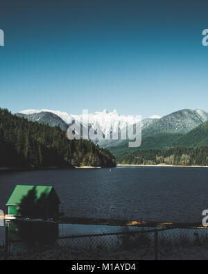 Vue sur le mont Grouse et son paysage environnant de Capilano Lake / barrage Cleveland, North Vancouver, Colombie-Britannique, Canada en hiver Banque D'Images