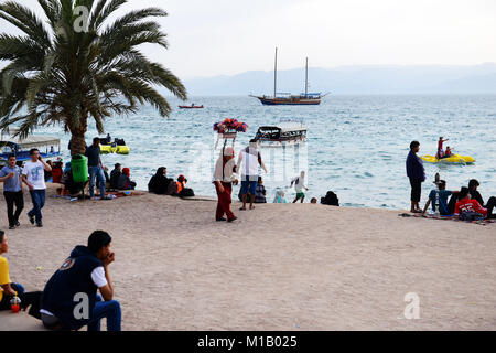 Un vendeur de jus de tamarin traditionnelle marche sur Al-Ghandour Beach à Aqaba, Jordanie. Banque D'Images