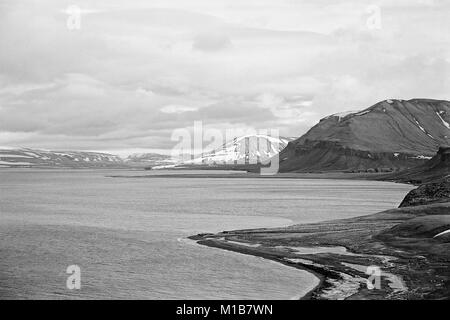 Sous une couverture de nuages, l'océan Arctique offertes sur les rives de l'île de Spitsbergen. Dans l'avant-plan tall montagnes grises parsemées de neige. Prise en 1995 Banque D'Images