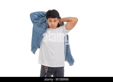 Un garçon aux cheveux noirs asiatiques sur place dans studio avec chemise blanche et veste de jeans. Banque D'Images