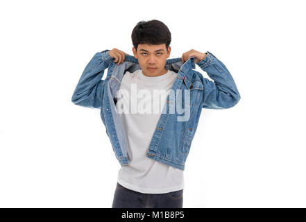 Un garçon aux cheveux noirs asiatiques sur place dans studio avec chemise blanche et veste de jeans. Banque D'Images