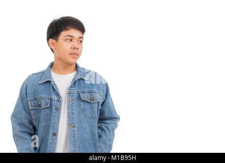 Un garçon aux cheveux noirs asiatiques sur place dans studio avec chemise blanche et veste de jeans. Banque D'Images