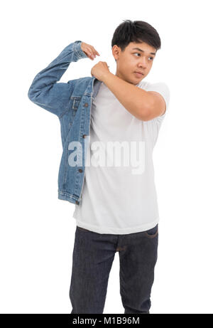 Un garçon aux cheveux noirs asiatiques sur place dans studio avec chemise blanche et veste de jeans. Banque D'Images