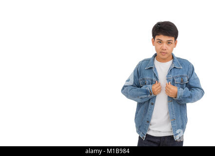 Un garçon aux cheveux noirs asiatiques sur place dans studio avec chemise blanche et veste de jeans. Banque D'Images