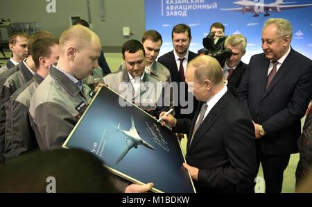 Le président russe Vladimir Poutine signe une photographie pour les travailleurs au cours d'une visite de l'usine d'aviation Gorbunov Kazan le 25 janvier 2018 à Kazan, Tatarstan, en Russie. Poutine a visité l'usine et les témoins d'une convention pour l'achat d'une version améliorée de l'avion supersonique Tupolev Tu-160 Blackjack bombardier stratégique. Banque D'Images