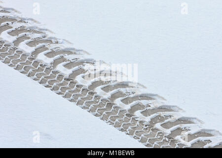 Les traces du tracteur sur la route couverte de neige. Vue de dessus. Banque D'Images