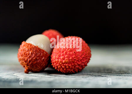 Trois fruits litchi sur fond sombre fermer Banque D'Images