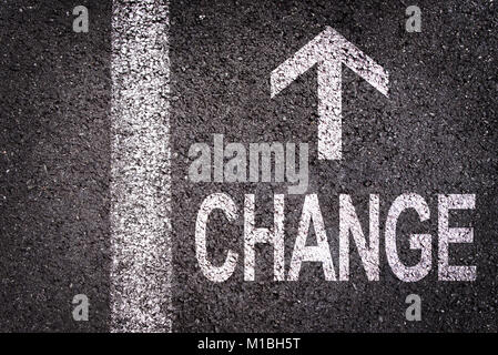Changer de mot et une flèche écrit sur une route asphaltée background Banque D'Images