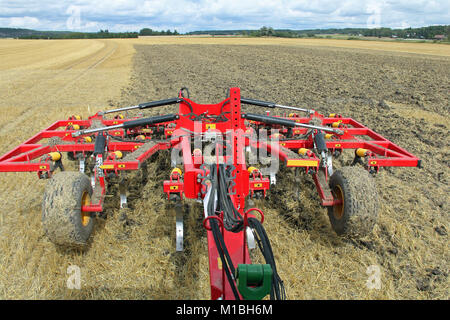 Labourant un champ de chaume avec le cultivateur vu depuis le tracteur. Banque D'Images