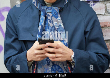 MILAN - JANUARY 15: Man with blue fur coat and Faure Le Page bag looking at  smartphone before Giorgio Armani fashion show, Milan Fashion Week street s  Stock Photo - Alamy