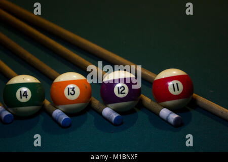 Billard 4 boules colorées avec cinq cue sur vert table de billard Banque D'Images