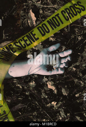 Scène du crime - main morte une feuille de chêne holdimg , enveloppé dans une bande de scène de crime Banque D'Images