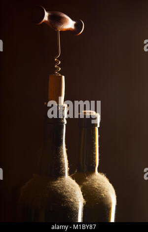 La nature morte avec de vieilles bouteilles de vin tire-bouchon et poussiéreux Banque D'Images