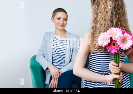 Happy Mother's Day, Journée de la femme ou d'anniversaire. Cute little girl offrir à maman bouquet de gerberas rose. Mère et fille concept. Banque D'Images