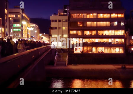 Licence disponible sur MaximImages.com - Izumoya bâtiment de restaurant japonais avec fenêtres illuminées la nuit et les personnes dînant à l'intérieur. Pont Shijo Banque D'Images