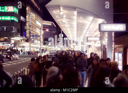 Personnes sur un trottoir de Shijo dori de nuit au centre-ville de Kyoto, Japon 2017 Banque D'Images