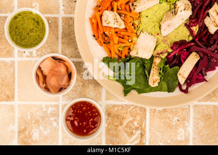 Style asiatique Salade de poulet cuits au feu avec du choux rouge Carottes Edamame Beans et l'hoummos sur un plan de travail cuisine carrelée ou Contre Banque D'Images