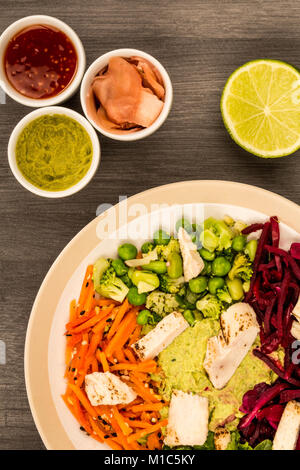 Style asiatique Salade de poulet cuits au feu avec du choux rouge Carottes Edamame Beans et l'hoummos contre un arrière-plan en bois foncé Banque D'Images