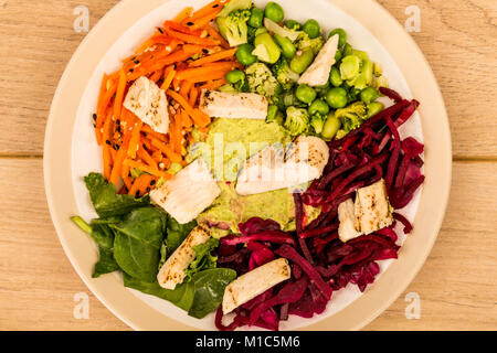 Style asiatique Salade de poulet cuits au feu avec du choux rouge Carottes Edamame Beans et l'hoummos contre un arrière-plan ou sur une table en bois clair Banque D'Images