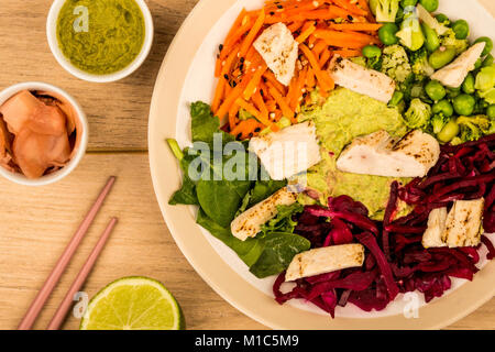 Style asiatique Salade de poulet cuits au feu avec du choux rouge Carottes Edamame Beans et l'hoummos contre un arrière-plan ou sur une table en bois clair Banque D'Images