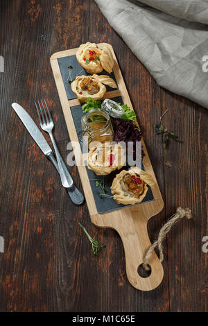 Tartelettes avec le pâté de foie de canard ou foie de poulet et une sauce d'argousier sont sur le plateau. Banque D'Images