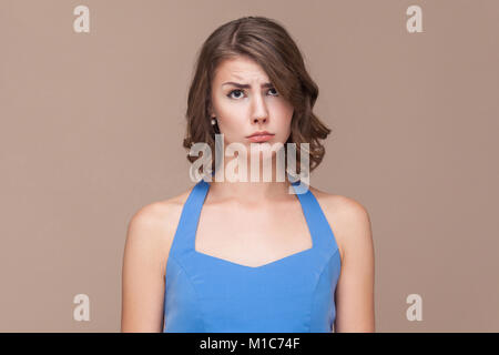 Malheureux business woman looking at camera et pleurer. Studio shot, fond brun clair Banque D'Images
