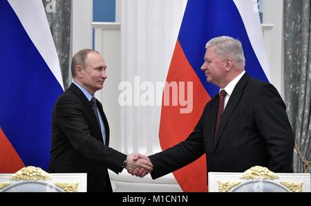 Le président russe Vladimir Poutine, gauche, serre la main avec la Fédération des Syndicats indépendants de la Russie le Président Mikhail Shmakov au cours d'une cérémonie de signature entre la Fédération des syndicats, les employeurs et le gouvernement russe, le 29 janvier 2018 à Moscou, Russie. L'accord régit les relations de travail pour les trois années à venir pour plus de 70 millions de travailleurs russes. Banque D'Images