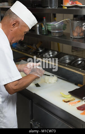 Senior chef de la préparation des sushis dans la cuisine Banque D'Images