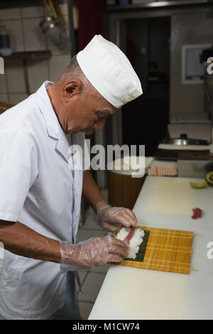 Senior chef de la préparation des sushis dans la cuisine Banque D'Images