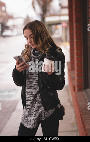 Belle fille à l'aide de mobile alors que le café Banque D'Images