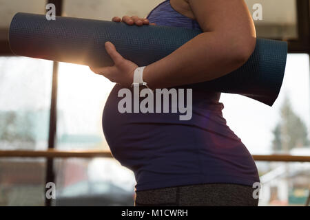 Pregnant woman holding tapis d'exercice à la maison Banque D'Images