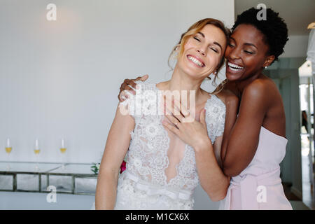 Magnifique mariée robe de mariage en s'amusant avec de demoiselle d'chambre d'hôtel. Mariée de demoiselle d'honneur et joyeuse le jour du mariage. Banque D'Images