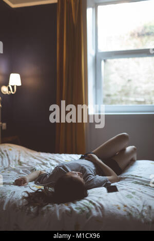 Woman in bedroom Banque D'Images