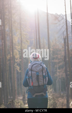 Female hiker debout avec sac à dos dans la forêt Banque D'Images