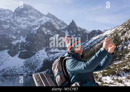 Female hiker taking photo with mobile phone Banque D'Images