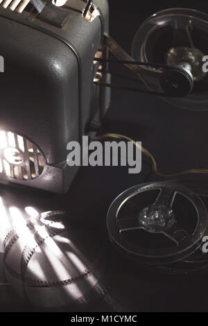 Ancien projecteur de film et des cassettes dans le noir Banque D'Images