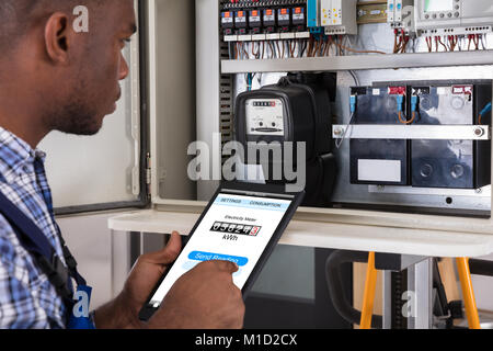 Lecture de compteur Faire Technicien de sexe masculin à l'aide de Tablet Banque D'Images