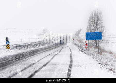 Snowy route asphaltée, les véhicules allant à la card Banque D'Images