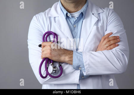 Médecin homme avec stéthoscope médical sur fond gris Banque D'Images