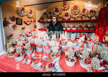 Helsinki, Finlande - le 11 décembre 2016 : femme vendant des cadeaux souvenirs de Noël en forme de paniers en osier et des couronnes à l'hiver européen marque Noël Banque D'Images