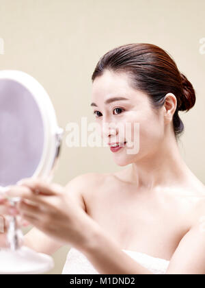 Belle jeune femme asiatique se voir en miroir, heureux et souriant. Banque D'Images