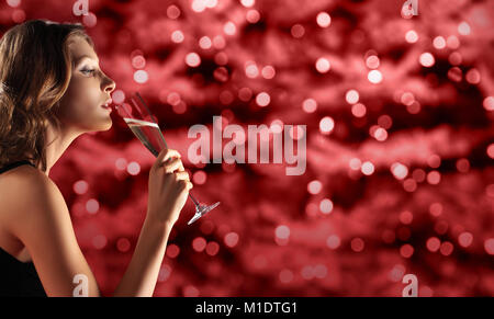 Toast New Year's Eve, femme à boire le vin pétillant sur rouge seau en modèle de page with copy space Banque D'Images