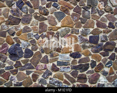 Mosaic wall bordée de pierres naturelles de différentes couleurs. Banque D'Images