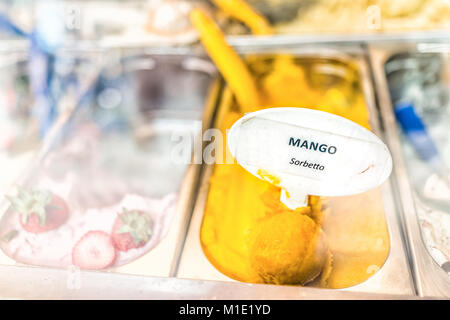 Gros plan macro de saveur mangue sorbet orange jaune crème glacée à signer sur l'affichage en magasin cafe shop avec écope en Italie, l'Italien sorbetto Banque D'Images
