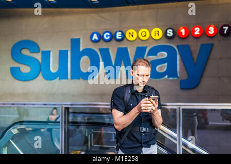 Gros plan du jeune homme tourisme voyage millénaire hipster face à la recherche, à l'aide de mobile smartphone en métro Métro à NYC New York City Manhattan downtow Banque D'Images