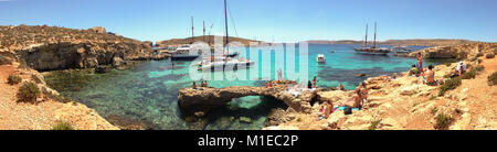 Le Blue Lagoon en Comino Island au large de la côte de Malte, ici l'bateaux s'arrêtent pour permettre aux passagers de se baigner dans l'eau bleu clair. Banque D'Images