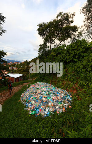 Balades touristiques cours des tas de bouteilles en plastique aplati dans la végétation sous-évaluées en regard de sentier, Coroico, yungas, Bolivie Banque D'Images