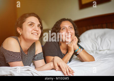 Deux amies se coucha sur lit et regarder devant Banque D'Images