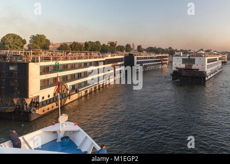 L'après-midi chaud lumière baigne les bateaux de croisière comme ils se bousculent pour la position sur le quai près de Kom Ombo temple sur le Nil, l'Egypte Banque D'Images