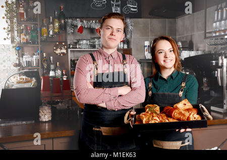 Couple de barista debout près de boulangerie dans un coffee shop. Bel homme et femme séduisante sont faire du café. Concept de l'industrie des aliments et boissons Banque D'Images